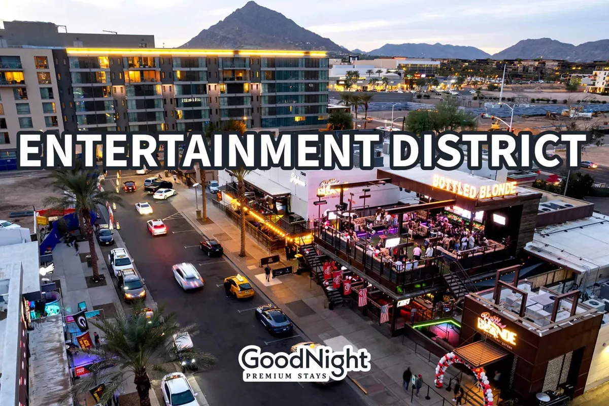 The illuminated Entertainment District signage sets the scene, with Bottled Blonde bar and other nightlife spots buzzing along a lively street. The evening ambiance is underscored by streetlights, parked cars, and a dynamic mix of people, reflecting the electric nightlife atmosphere.