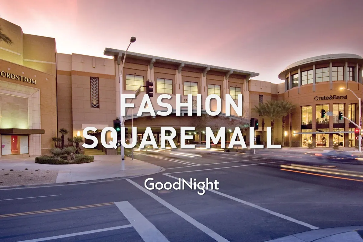 A lively exterior scene of Scottsdale Fashion Square, featuring the Nordstrom storefront, Crate & Barrel entrance, and palm trees lining the street. Shoppers and diners create a bustling, upscale atmosphere indicative of the area's boutique shopping and social opportunities.